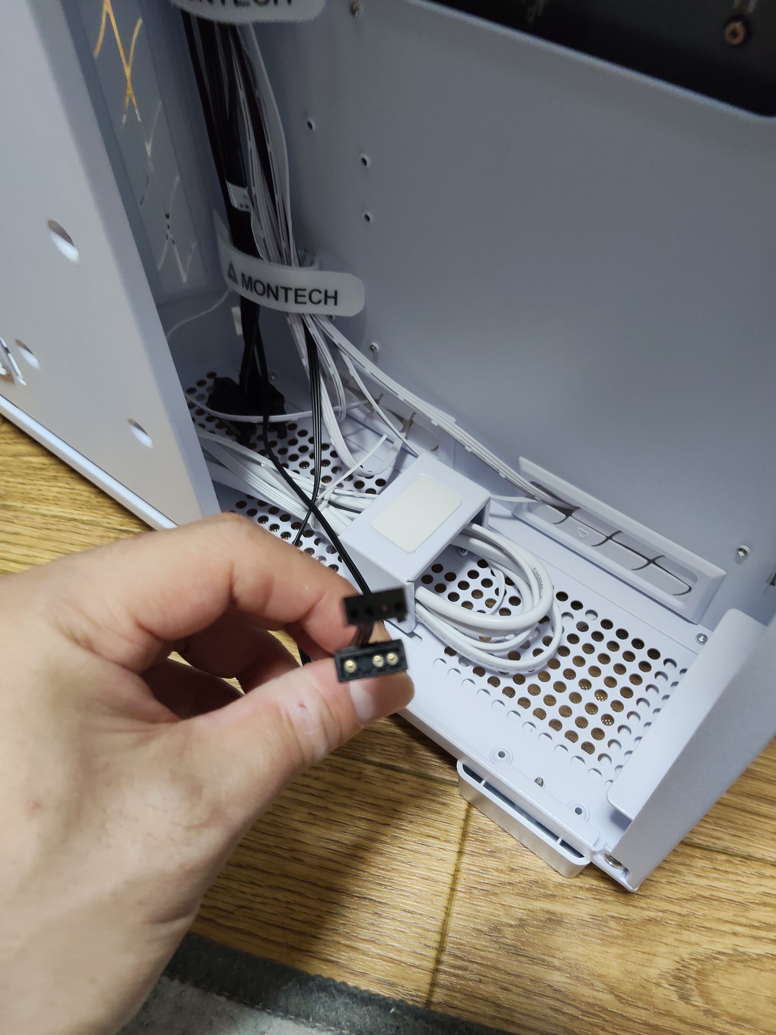 ARGB ハブの黒 3-pin コネクタを手で持つ（接続前）